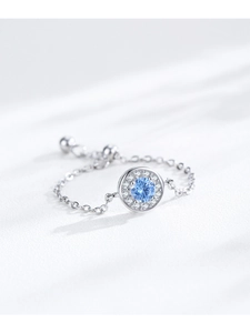 Détail d'une bague chaîne ajustable en argent S925 avec une pierre précieuse bleue ronde