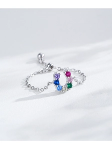 Macro shot of silver horseshoe ring featuring multi-color pavé set cubic zirconia stones