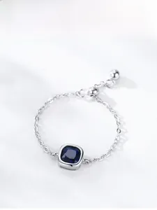 Détail macro d'une bague chaîne ajustable en argent S925 avec saphir bleu carré