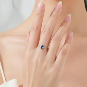925 silver adjustable chain ring with oval blue gemstone worn on female hand
