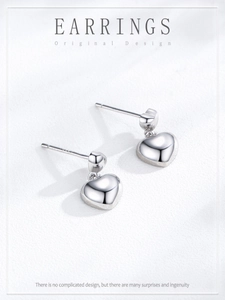 Macro shot of S925 sterling silver heart earrings with polished finish and hallmark