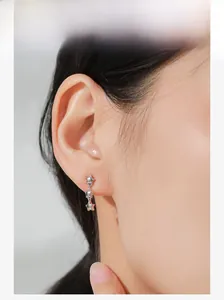 Detail shot of 925 sterling silver triple star drop earrings worn by a model