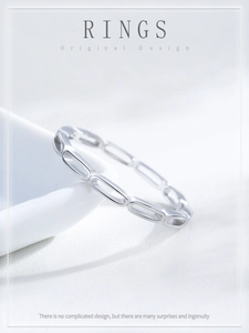 Macro shot of S925 sterling silver hollow chain ring on a white porcelain dish