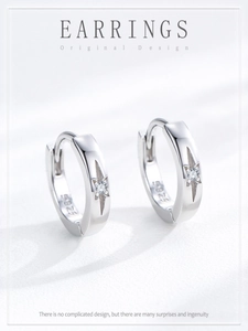 Détail des créoles en argent 925 avec gravure d'étoile et petit diamant scintillant
