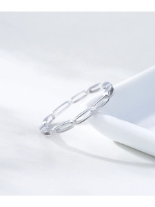 Macro shot of silver S925 hollow chain link ring on white ceramic edge