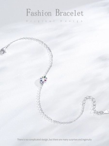 Detail of S925 sterling silver stamp and colorful zircon snail charm on a fine chain