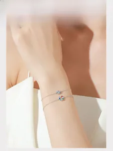 Detail of S925 silver horseshoe bracelet with colorful zircon stones on model wrist