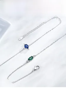 Detailed close-up of S925 sterling silver bracelet with oval emerald and sapphire stones