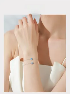 Dettaglio dei bracciali Cuore dell'Oceano in argento con zaffiri blu indossati al polso