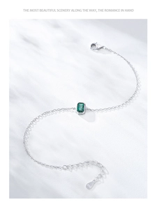Detailed close-up of S925 sterling silver chain with emerald-cut green stone pendant