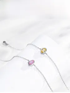 Close-up of S925 sterling silver chain bracelets with amber and pink zircon pendants