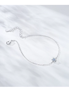 Macro shot of S925 sterling silver flower bracelet with blue gemstone and lobster clasp