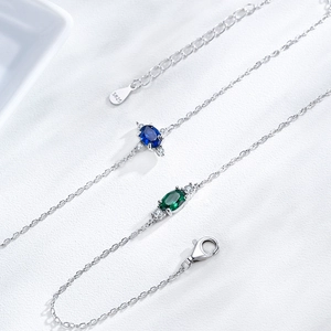 S925 sterling silver chain bracelet with oval sapphire and emerald stones in a macro view