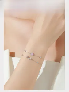 Détail d'un bracelet double couche en argent S925 avec pierres roses et motif LOVE