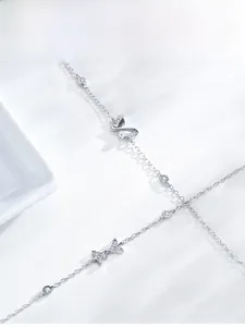 Macro shot of silver hollow butterfly charm bracelet with sparkling zircon stones