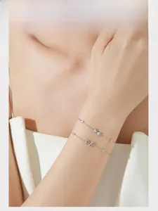 Detail of S925 sterling silver butterfly bracelets with pavé zircons on model wrist