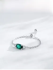 Close-up of silver chain ring featuring an oval green gemstone and adjustable slider bead