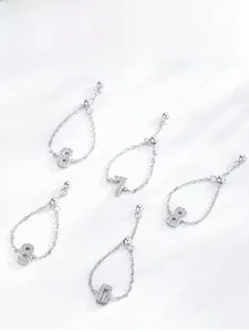 Dettaglio di anelli a catena in argento S925 con pendenti numerici scintillanti da 6 a 0