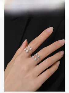Detail of four S925 silver rings with pear and marquise-cut zircons worn on hand