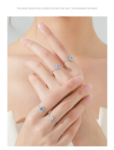 Close-up of four-piece silver chain rings set with blue zircons on model fingers