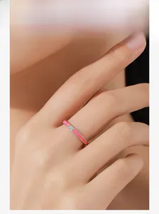 Detail of S925 sterling silver ring with pink enamel and square cubic zirconia on finger