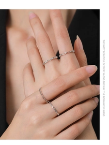 Close-up of three minimalist S925 sterling silver rings worn on fingers with a sleek finish