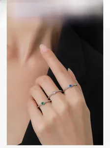 Close-up of minimalist S925 silver ring set with emerald, pink, and sapphire gemstones