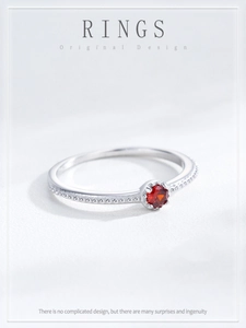 Détail macro de la bague en argent S925 avec zircon rouge et bordure perlée texturée