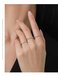 Close-up of stacked S925 sterling silver geometric rings with twisted rope texture