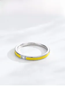 Detail view of S925 sterling silver ring with yellow enamel and a sparkling central gemstone