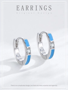 Détail des boucles d'oreilles huggies en argent S925 avec émail bleu et zircone