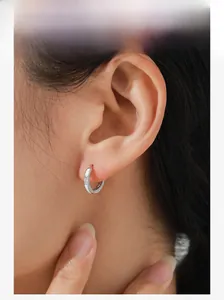 Model wearing a minimalist S925 sterling silver hoop earring with clear cubic zirconia