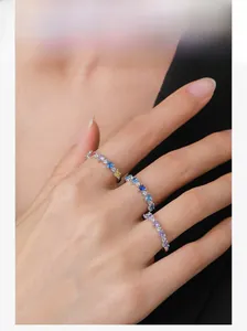 Close-up of three stacked S925 silver rings with multi-color heart-shaped zircon stones