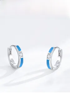 Detailed macro view of S925 sterling silver hoop earrings with blue enamel and zircon stone