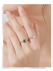 Detailed view of S925 silver chain rings with emerald cut green and pear white zircon