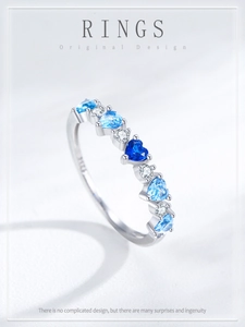 Macro view of S925 silver ring featuring gradient blue heart stones and white zircons