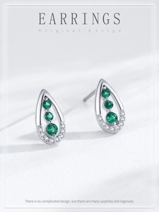 Detail of silver drop earrings with green emerald zircons and micro-pave crystals