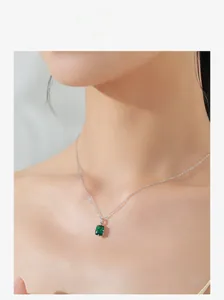 Macro view of rectangle emerald zircon pendant necklace in 925 silver on woman neck