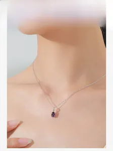 Modell trägt eine S925 Silberhalskette mit einem lila Kristallanhänger in Tropfenform