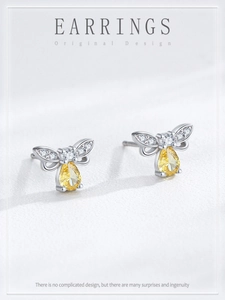 Détail des boucles d'oreilles abeille en argent avec cristaux et pierres jaunes