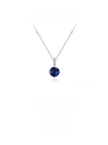Macro detail of round blue sapphire pendant with four-prong silver setting