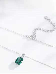 Detail of 925 silver necklace with emerald zircon pendant and adjustable heart tag