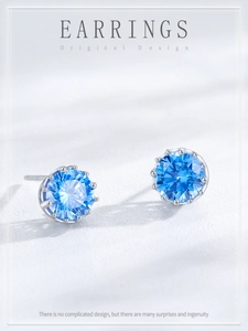 Close-up of crown-set S925 silver studs with round light blue aquamarine zirconia