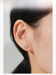 Gros plan de boucles d'oreilles abeille en argent S925 avec pierre jaune sur l'oreille