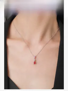 Detail of S925 silver necklace with pink and red teardrop gems on a model