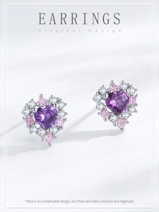 Dettaglio macro di orecchini a cuore in argento S925 con zircone viola e pietre
