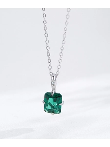 Macro view of emerald-cut green gemstone pendant on a 925 silver cable chain necklace