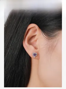Primo piano dettagliato di un orecchino con zircone viola a cuore indossato da una modella
