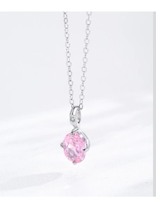 Close-up of pink oval zircon pendant with spiral silver prongs on silver chain