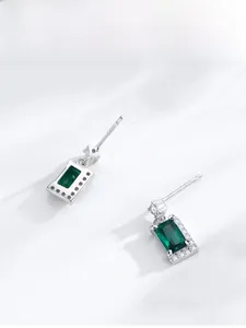 Close-up of S925 sterling silver studs with emerald-cut green zircon and halo stones